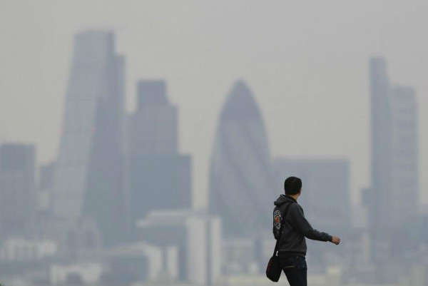 Người đàn ông đi qua Công viên Greenwich khi bầu trời dày đặc sương khói ở London, Anh vào ngày 3/4/2014. Ảnh: Luke MacGregor