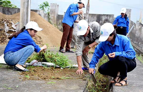 Đoàn viên thanh niên tham gia dọn vệ sinh tại khuôn viên Ban Quản lý Nước sạch và Vệ sinh môi trường huyện Văn Chấn