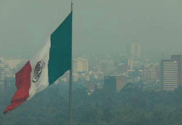 Hình ảnh lá cờ Mexico trong không khí mờ ảo của các tòa nhà ở thành phố Mexico vào ngày 14/5/2019 khi chính quyền nơi đây tuyên bố tình trạng khẩn cấp về môi trường cùng ngày tại thành phố. Ảnh: Henry Romero