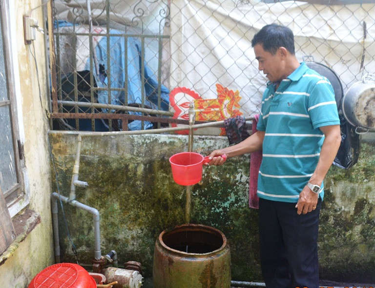 Nguồn nước máy yếu, ông Trần Nhàn phải hứng từ sáng đến trưa mới được một lu nước để gia đình sinh hoạt, ăn uống