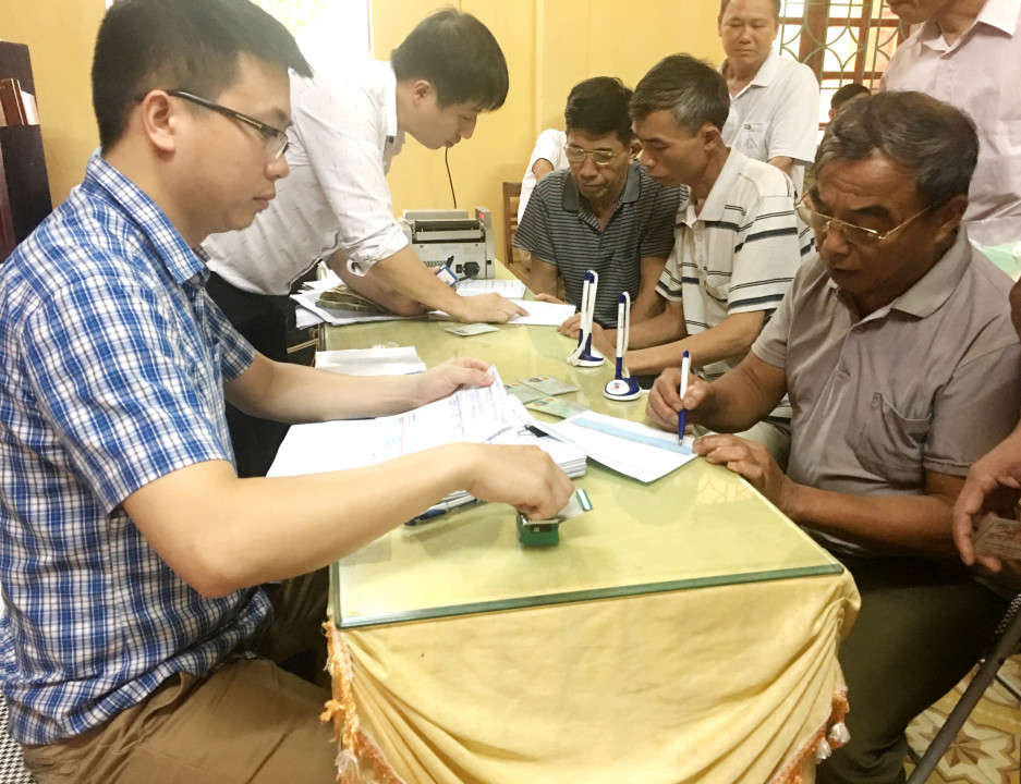 Nhân viên ngân hàng chi trả tiền DVMTR và hướng dẫn người dân tại xã Xuân Long trong việc sử dụng tại khoản ngân hàng.