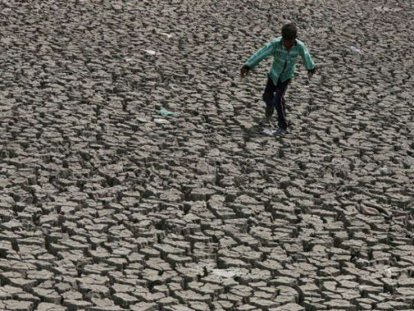 Một cậu bé đi bộ qua hồ khô ở thành phố Ahmedabad, Ấn Độ vào ngày 1/5/2019. Ảnh: Reuters / Amit Dave