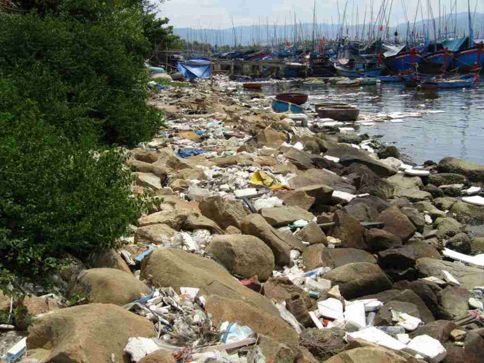 Những vệt rác trắng xóa nằm uốn lượn theo triền bờ cửa biển