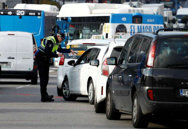 Cảnh sát giao thông hướng dẫn người lái xe vào trung tâm trong ngày đầu tiên thực hiện sắc lệnh thành phố cấm một số phương tiện không có nhãn dán phù hợp theo khí thải của họ ở Madrid, Tây Ban Nha, ngày 30/11/2018. Ảnh: Paul Hanna