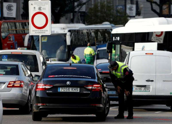 Cảnh sát giao thông trao đổi với người lái xe vào trung tâm trong ngày đầu tiên thực hiện sắc lệnh thành phố về việc cấm một số phương tiện không dán nhãn khí thải phù hợp ở Madrid, Tây Ban Nha, ngày 30/11/2018. Ảnh: Reuters / Paul Hanna
