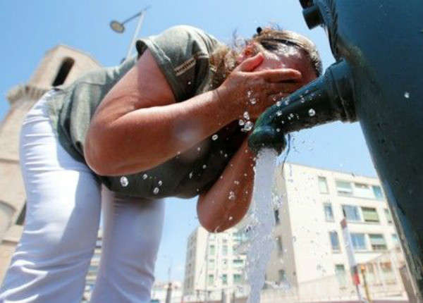 Người phụ nữ rửa mặt tại một đài phun nước ở Marseille, Pháp khi một đợt nắng nóng tấn công phần lớn đất nước