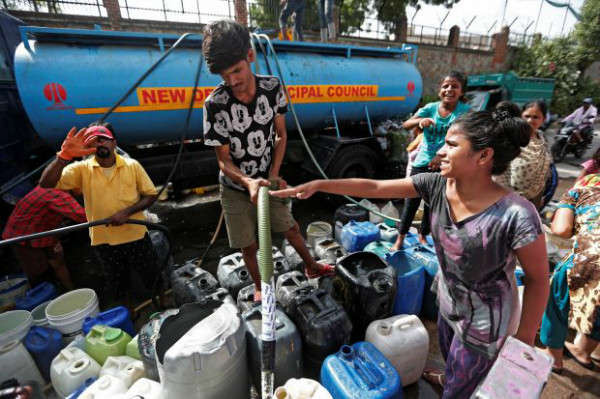 Người dân đổ đầy nước vào thùng chứa nước từ một xe chở nước của thành phố ở New Delhi, Ấn Độ vào ngày 28/6/2019. Ảnh: Adnan Abidi