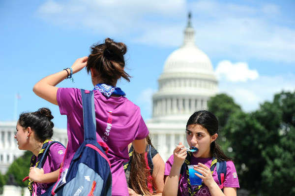 Các du khách nhí đến từ Chile, Emilia Aguirre, 14 tuổi và Beatriz Catalan, cũng 14 tuổi và Magdalena Chahuan, 15 tuổi đi bộ trong một ngày nắng nóng trước Tòa nhà Quốc hội Mỹ ở Washington vào ngày 18/7/2019. Ảnh: Reuters / Mary F. Calvert