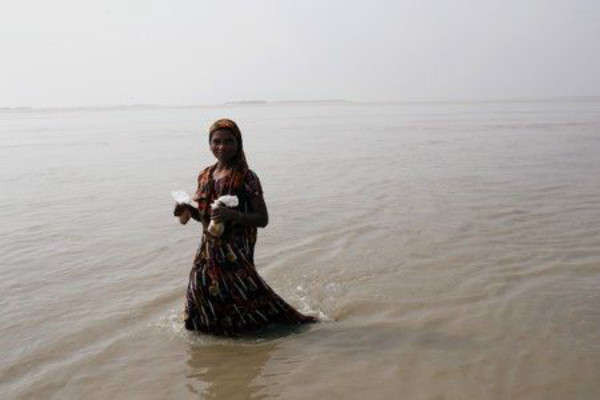Một người phụ nữ bị ảnh hưởng bởi lũ lụt lội qua khu vực ngập lụt ở Jamalpur, Bangladesh vào ngày 21/7/2019. Ảnh: Reuters / Mohammad Ponir Hossain