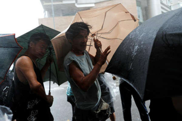 Mọi người chống chọi với mưa lớn khi cơn bão Wipha đổ bộ Hồng Kông, Trung Quốc vào ngày 31/7/2019. Ảnh: Reuters / Tyrone Siu