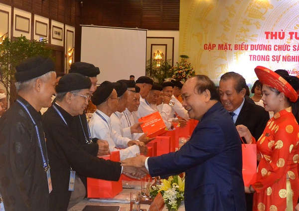 Thủ tướng Nguyễn Xuân Phúc tặng quà cho các chức sắc, chức việc tôn giáo tham dự buổi gặp mặt. 