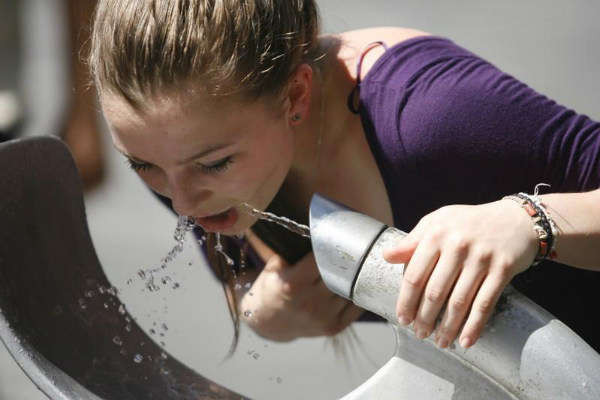 Một người phụ nữ uống nước từ đài phun nước trong một ngày nắng nóng ở trung tâm Sydney vào ngày 5/1/2010. Ảnh: Daniel Munoz