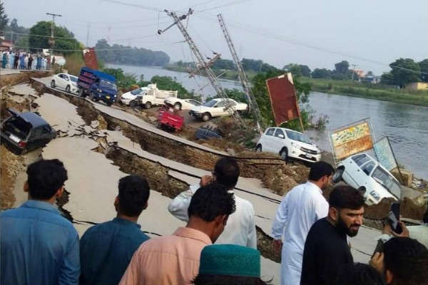 Mọi người tập trung gần một con đường bị hư hại sau trận động đất mạnh 5,8 độ ở Mirpur, Pakistan vào ngày 24/9/2019. Ảnh: Stringer