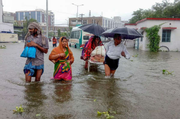 Bệnh nhân lội qua nước lũ trên đường đến bệnh viện trong cơn mưa lớn ở thủ phủ Patna của bang Bihar, phía Đông Bắc Ấn Độ vào ngày 28/9/2019. Ảnh: AFP / Sachin KUMAR