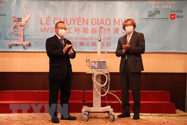 Ông Trần Ngọc Phúc (phải) bàn giao máy thở cho Đại sứ Vũ Hồng Nam. Ảnh: Đức Thịnh/TTXVN.