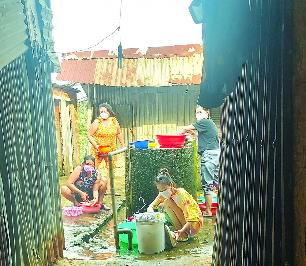 Công nhân tại khu trọ Ao Sen (120 phòng) đang dùng nước giếng khoan được bơm lên bồn chứa chung ẢNH: SƠN VINH